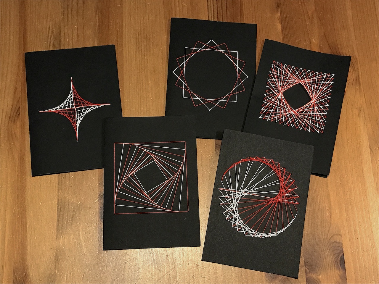 Five cards decorated with different string art motifs